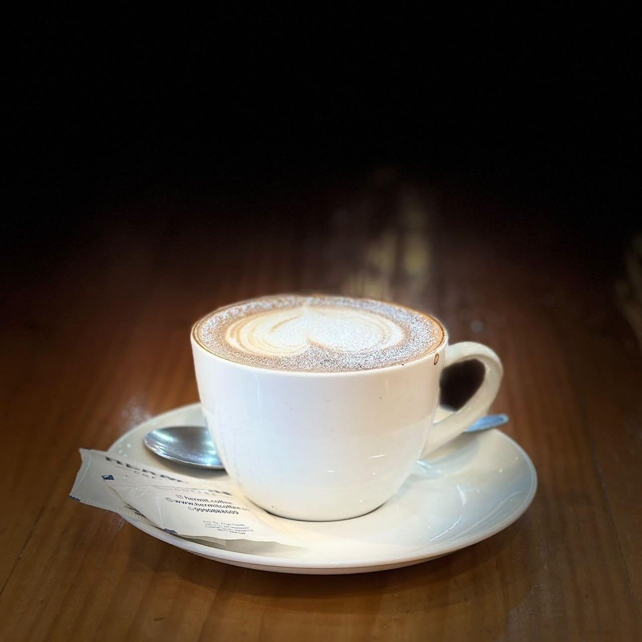 A cup of coffee and fresh croissants on a rustic wooden table